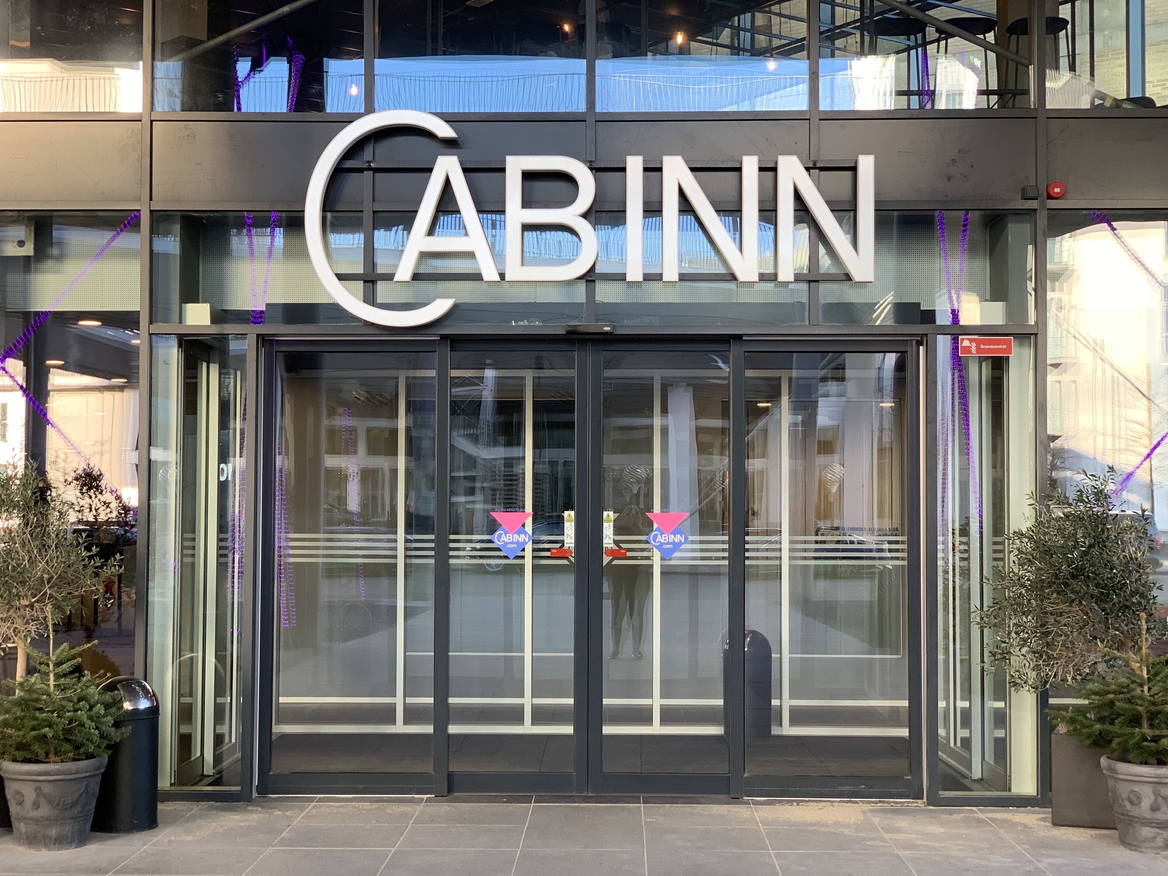 The exterior of a CABINN hotel with a glass entrance and signage.