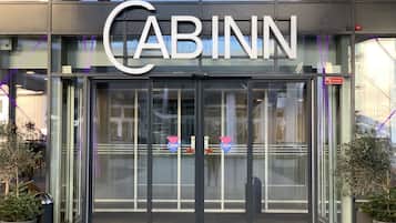 The exterior of a CABINN hotel with a glass entrance and signage.