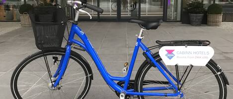 Una bicicleta azul estacionada frente a un edificio con el letrero "CABINN".