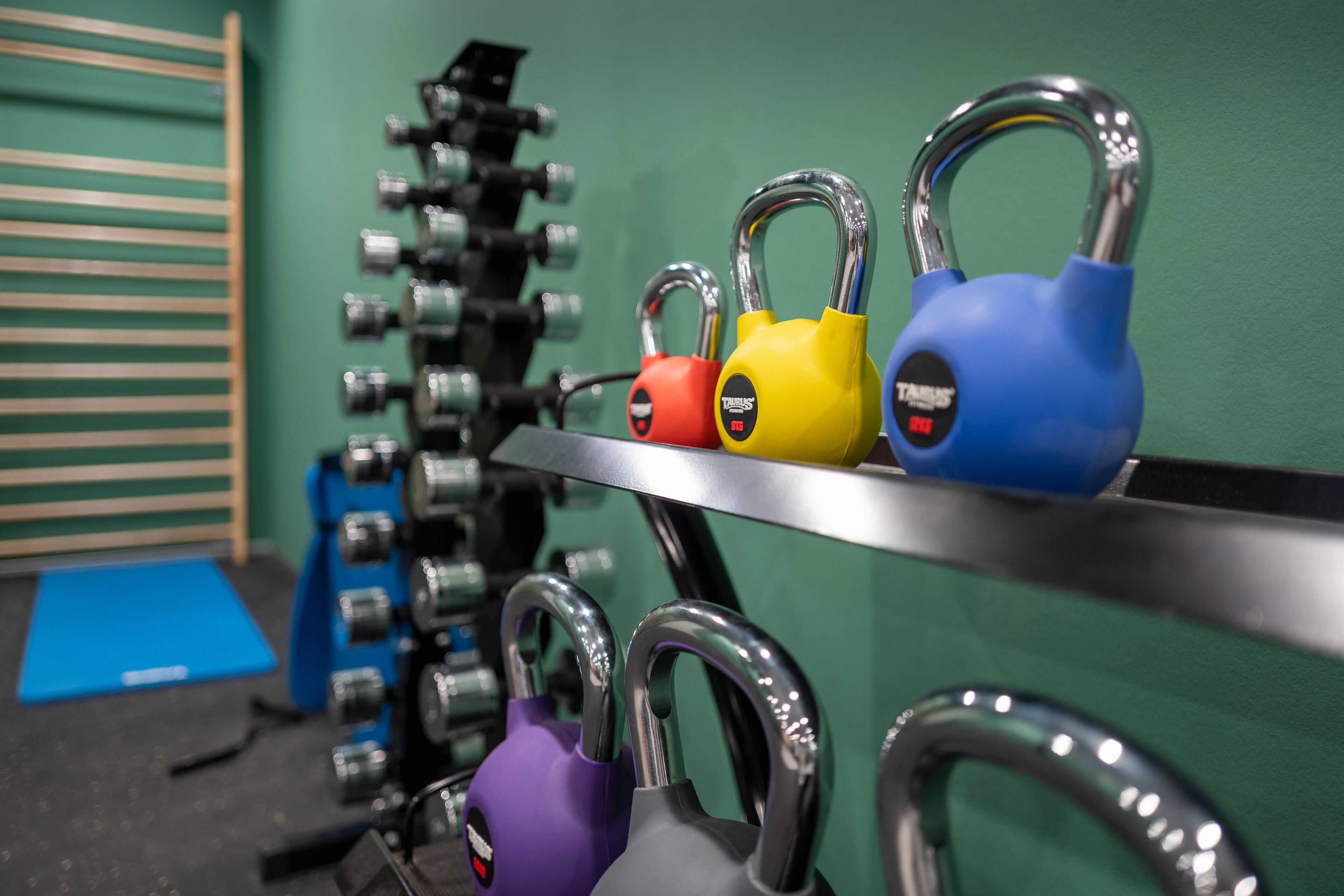 A rack of variously colored locks, a blue mat, and a green wall.