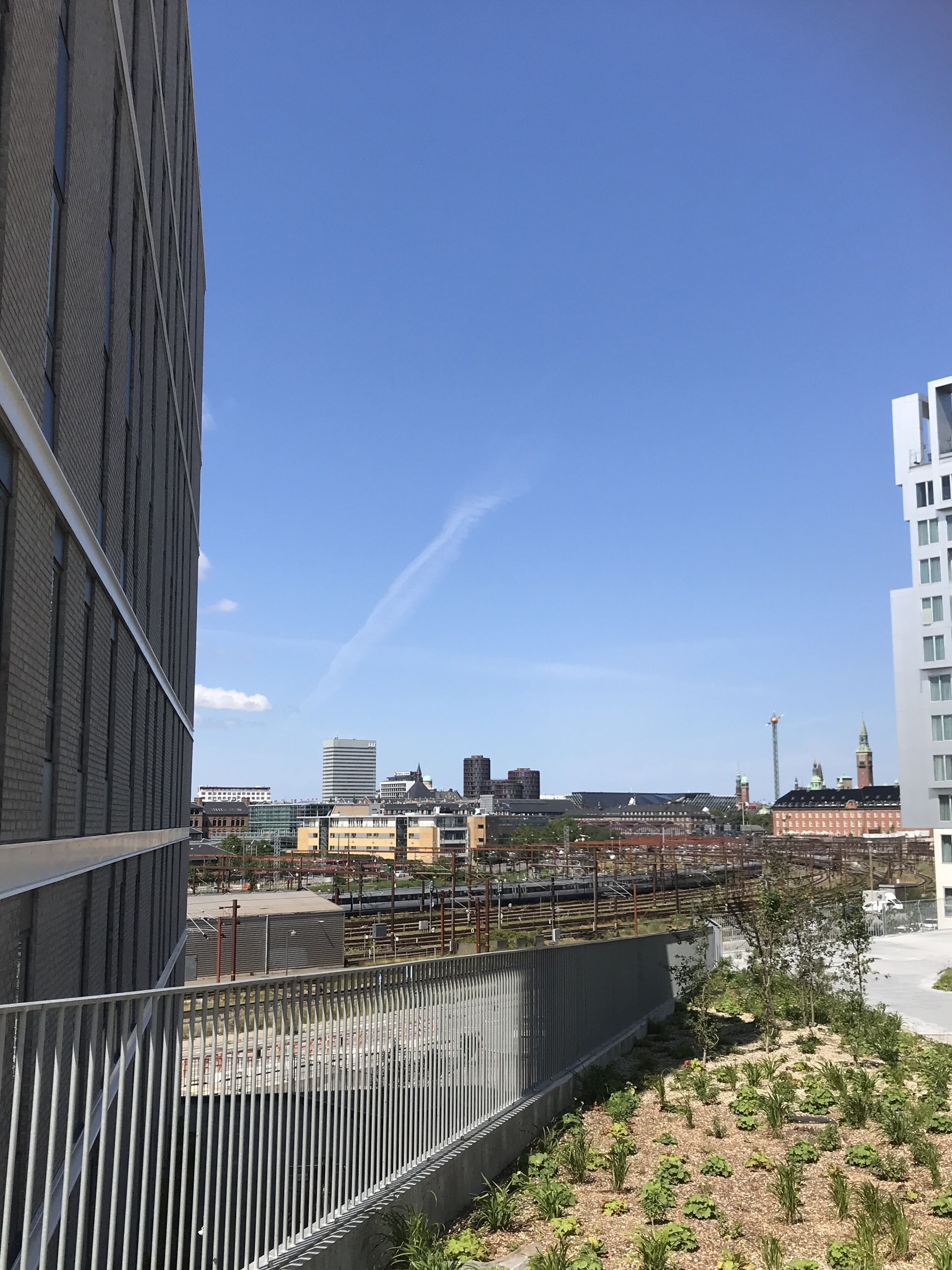 Un edifici modern amb una tanca metàl·lica i una zona de jardí.