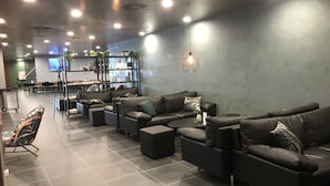 Un área de estar moderna con sofás de cuero, una mesa de centro y una pantalla de televisión.