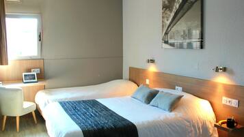 A hotel room with two beds, a desk, a chair, and a cityscape painting on the wall.