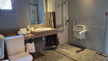Une salle de bain moderne équipée de toilettes, d’un lavabo, d’une douche et d’un miroir.