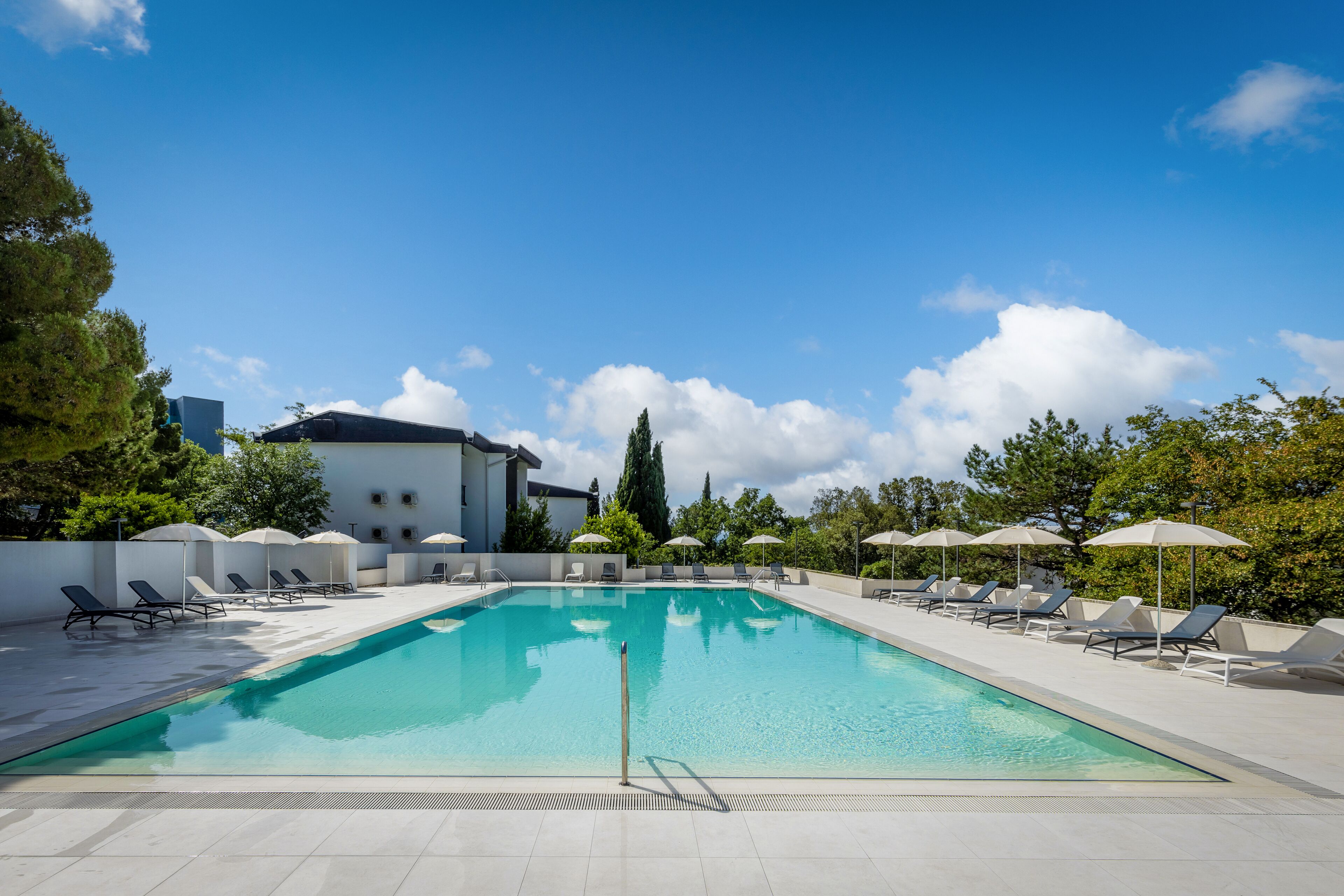 حمّام سباحة خارجي، مظلات على حمّام السباحة، مقاعد للتشمس