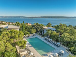 A resort with a swimming pool, lounge chairs, and a view of the sea. - Holiday Resort Ad Turres (Crikvenica)