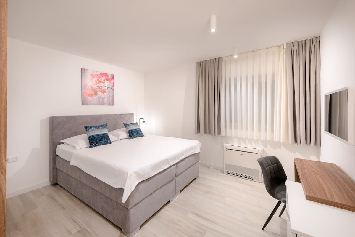 Een moderne slaapkamer met een bed, bureau en stoel.