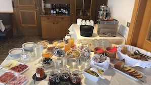 A breakfast buffet with various food items, including meats, cheeses, and pastries, arranged on a table. - Pension Volgger (Rodengo)