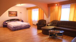 Ein Zimmer mit Bett, Sofa, Sessel und Couchtisch.