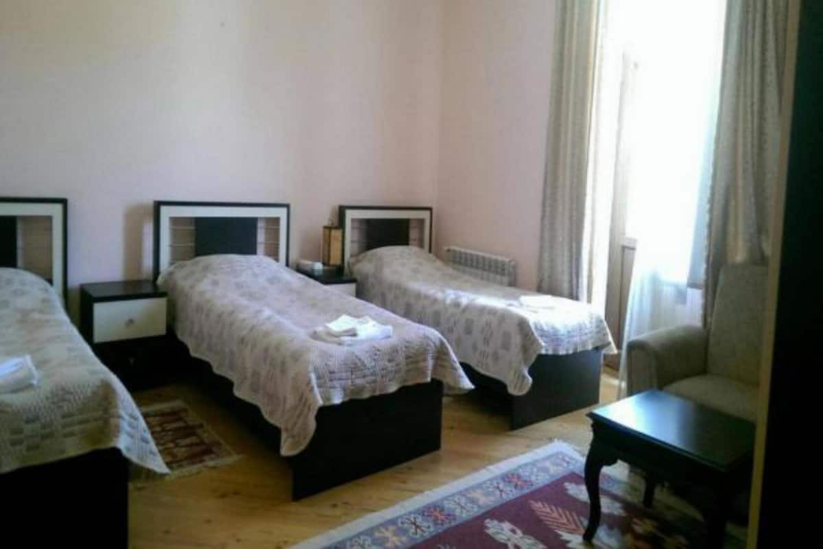 Habitación triple básica, 3 camas individuales, vista a la montaña | Área de sala de estar