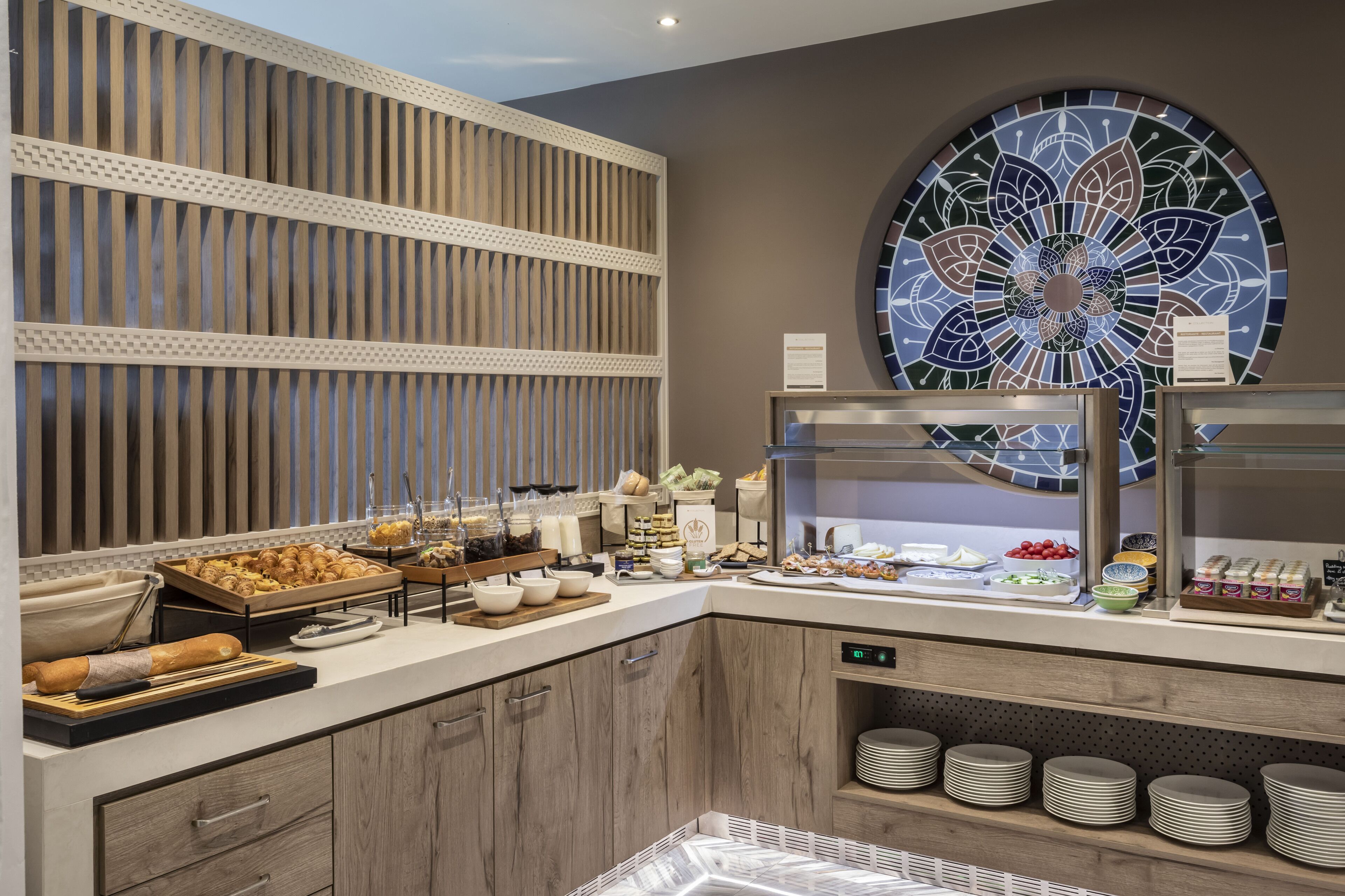 Ein reichhaltiges Buffet mit verschiedenen Speisen und einem dekorativen Glasfenster.
