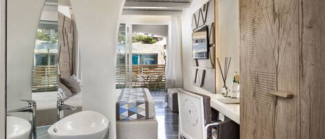 A modern bathroom with a freestanding bathtub, a large mirror, and a vanity with a marble countertop.
