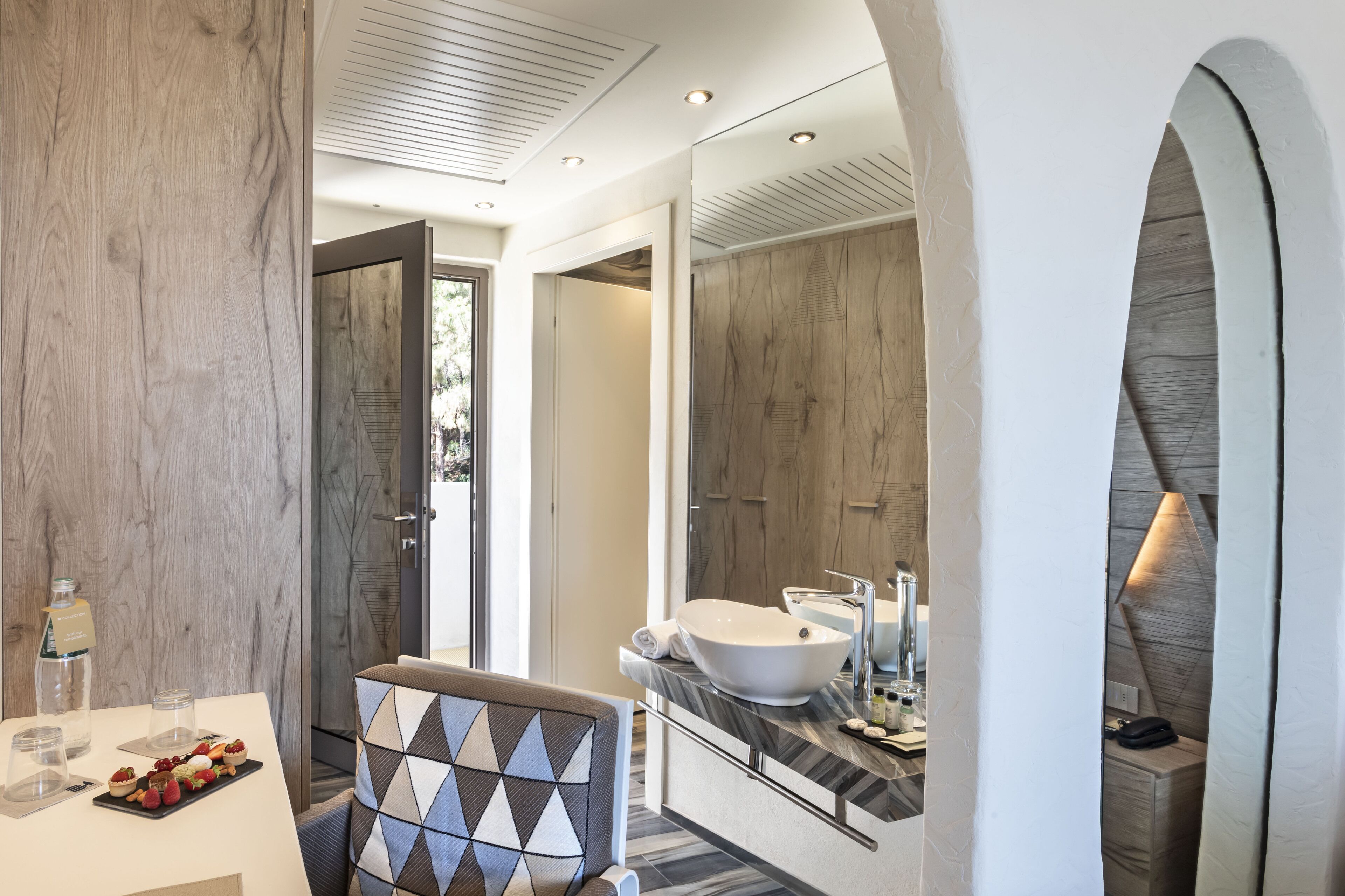A modern bathroom with a large mirror, a white sink, and a shower area.