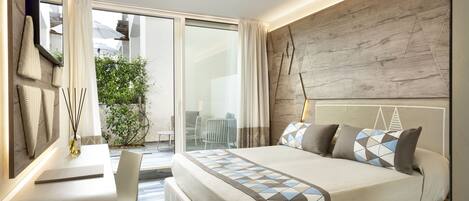 Habitación de hotel moderna con una cama grande, un escritorio y vistas al exterior.