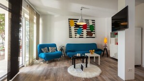 A modern living room with a blue sofa, a white coffee table, and a laptop on a fluffy rug. - Villa Zorana (Brela)