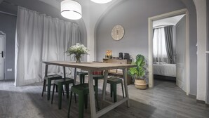 Una cocina moderna con una mesa de madera, taburetes verdes y un reloj en la pared.