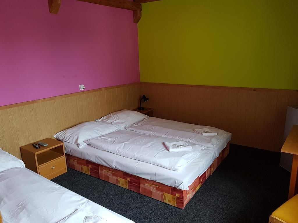 Una habitación con una cama, una mesita de noche y una lámpara.