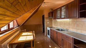 Una cocina con armarios de madera, una estufa y un ventanal.