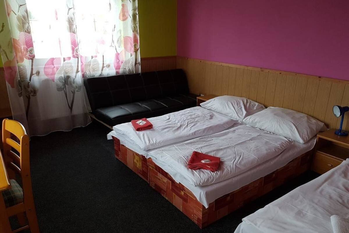 Une chambre avec un lit, une chaise et une table de chevet.