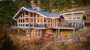 A modern multi-story house with large windows, a deck, and a staircase leading to the upper level. - Herondale Luxury Vacation  At Windcliff 3 Bedroom Home by RedAwning (Estes Park)