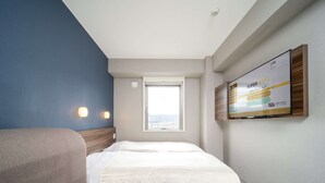 A hotel room with a bed, a sofa, a TV mounted on the wall, and a window providing a view. - Super Hotel Yamaguchi Yuda Onsen (Yamaguchi)