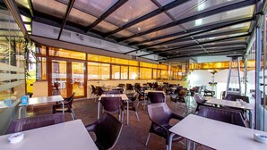 A spacious indoor dining area with tables and chairs, large windows, and a modern ceiling design. - Hospedium Hotel Don José (Castalla)