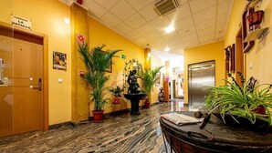 A hotel lobby with a marble floor, potted plants, a fountain, and a sign indicating the dining area. - Hospedium Hotel Don José (Castalla)