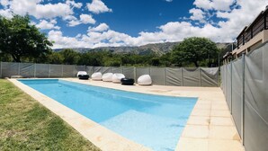 A swimming pool with a view of mountains in the background. - Aparts de Montana Tavullia (Carpintería)