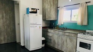 Cuina amb nevera, fogó i armaris.