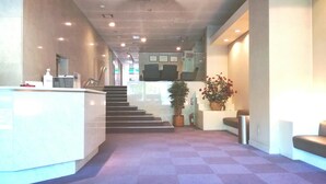 A reception area with a checkered floor, a reception desk, a staircase, and potted plants. - Hotel Satoh Tokyo (Tokyo)