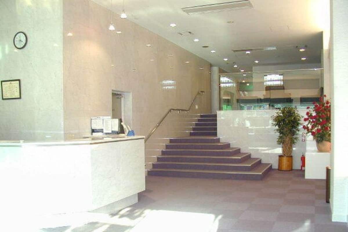 A reception area with a staircase, a reception desk, and a clock on the wall.