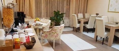 A dining area with a buffet setup, including a variety of food items and a plant centerpiece.