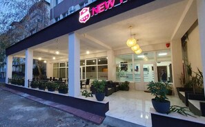 L’entrée d’un hôtel, avec un comptoir d’accueil, un espace salon et des plantes en pot.