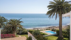 A pool with a view of the ocean, palm trees, and a beach. - A29 - Calheta House in Luz by DreamAlgarve (Lagos)