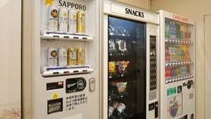Des distributeurs automatiques portant les mentions « Sapporo », « Encas » et « Boutique de boissons en conserve » proposent divers produits.