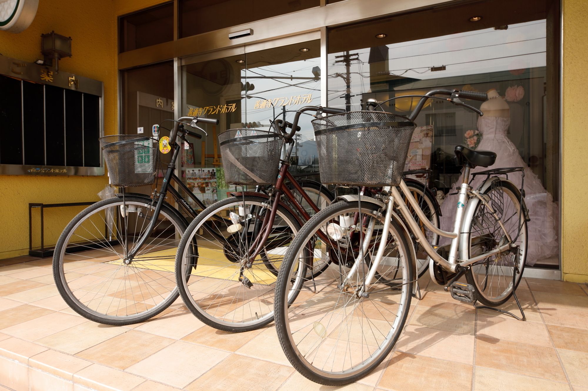 Tres bicicletas estacionadas frente a un edificio con entrada de azulejos.