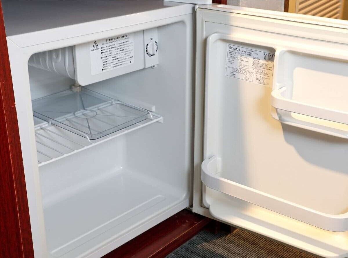 An open refrigerator with a control panel and a label on the door.