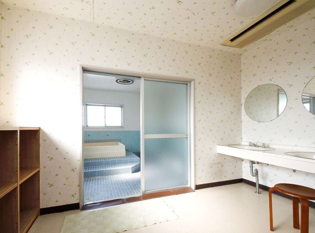Un baño con inodoro, lavamanos y espejo.