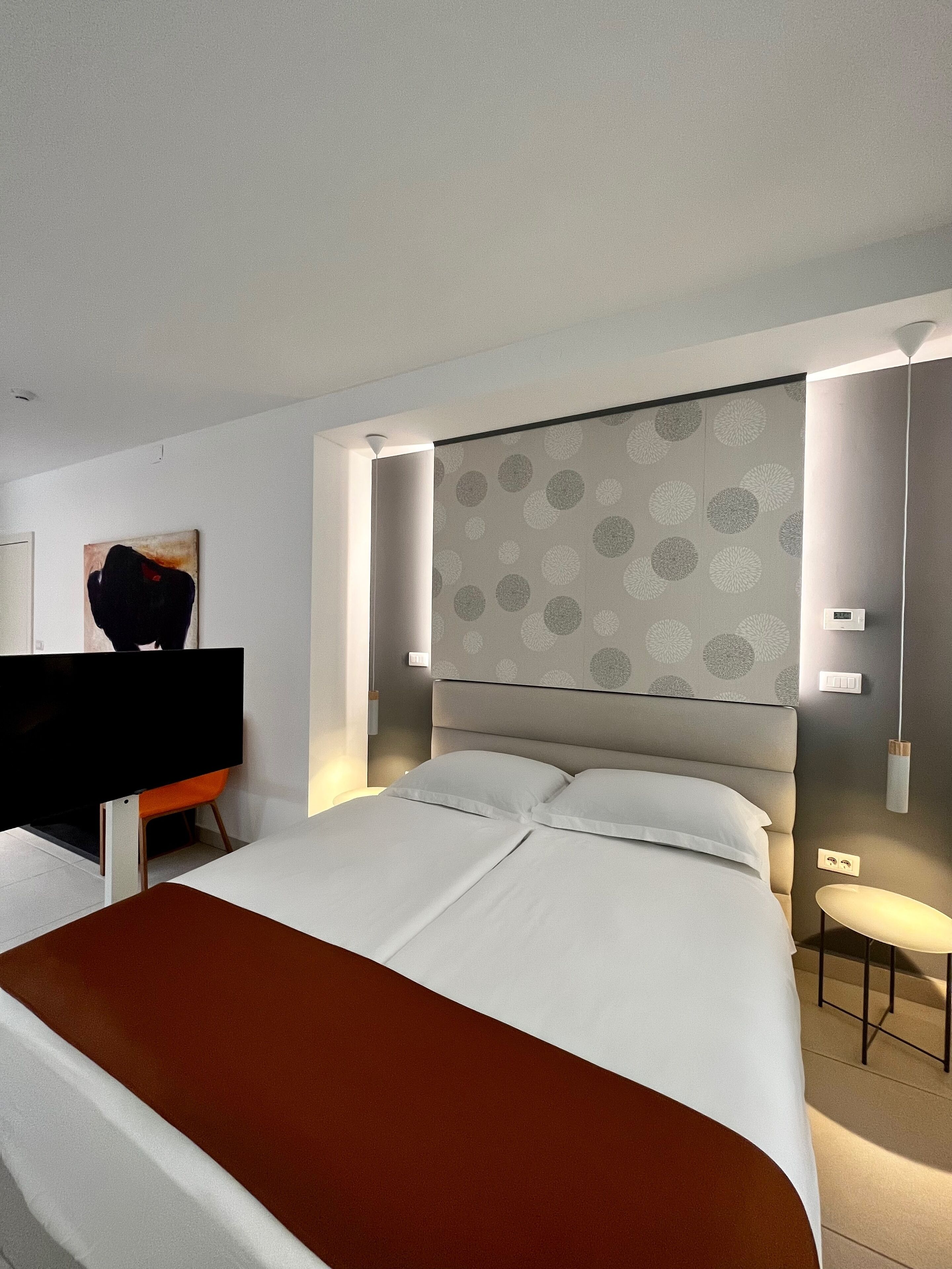Een moderne hotelkamer met een groot bed, een bureau en een stoel.