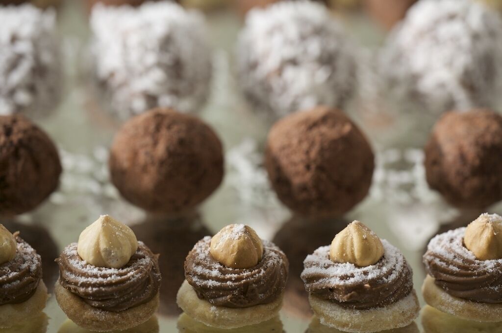 Una exhibición de postres con trufas de chocolate y pasteles rellenos de crema.