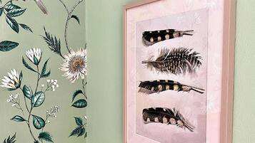 Una obra de arte enmarcadas con plumas de pájaro en una pared.