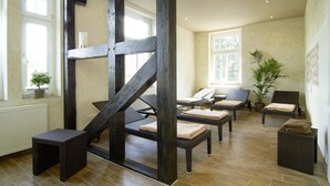 Une pièce dotée d’un escalier en bois, de fauteuils confortables et d’une grande fenêtre.