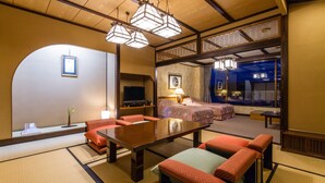 A traditional Japanese-style room with tatami flooring, a low table, and red cushions. - Yuyawan Onsen Hotel Yokikan (Nagato)