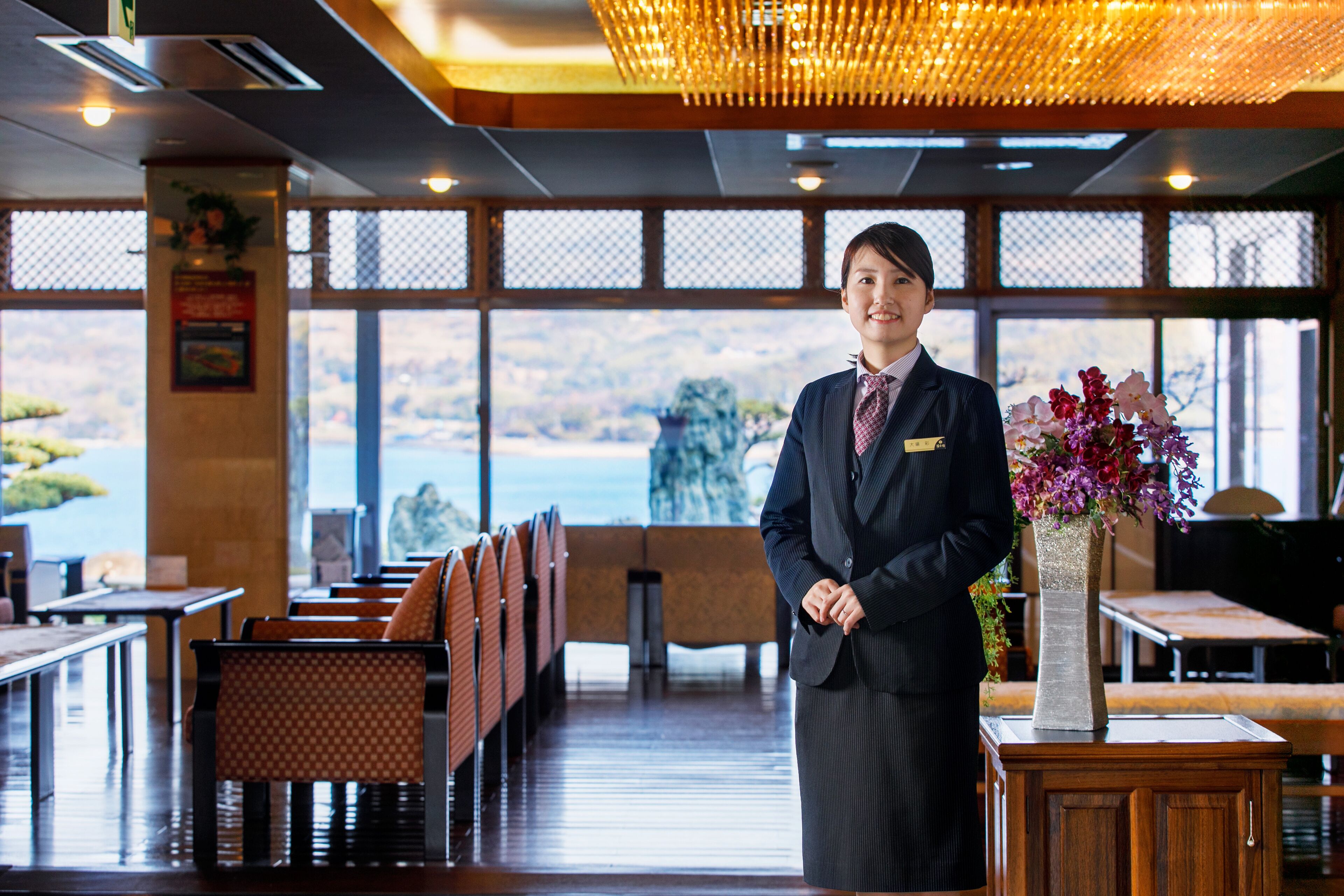 A hotel lobby with a reception area, seating arrangements, and a view of the outdoors.