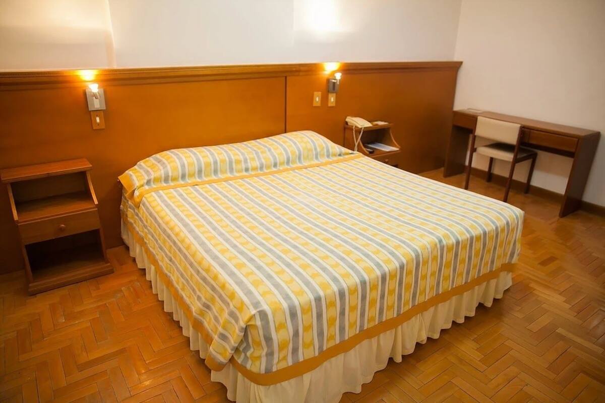 Ein Hotelzimmer mit einem großen Bett, einem Schreibtisch und einem Sessel.