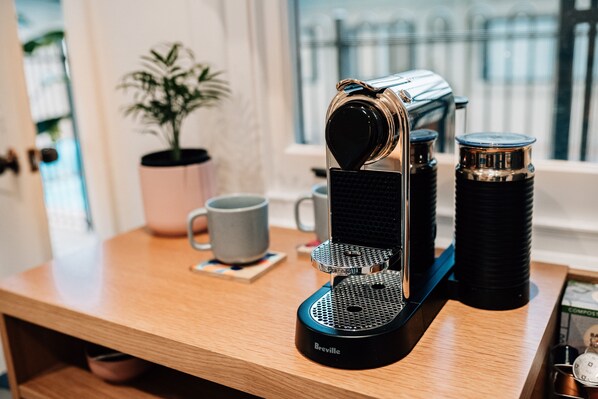 A Breville coffee maker on a wooden table with a potted plant and a mug in the background. - Tomfoolery Winegrower's Cottage (Light Pass)