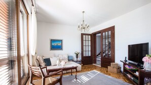Ett vardagsrum med en soffa, ett soffbord, en tv och en bokhylla.