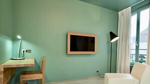 A room with a desk, chair, and a white sofa. - Hidden Bay Hotel (Cayeux-sur-Mer)