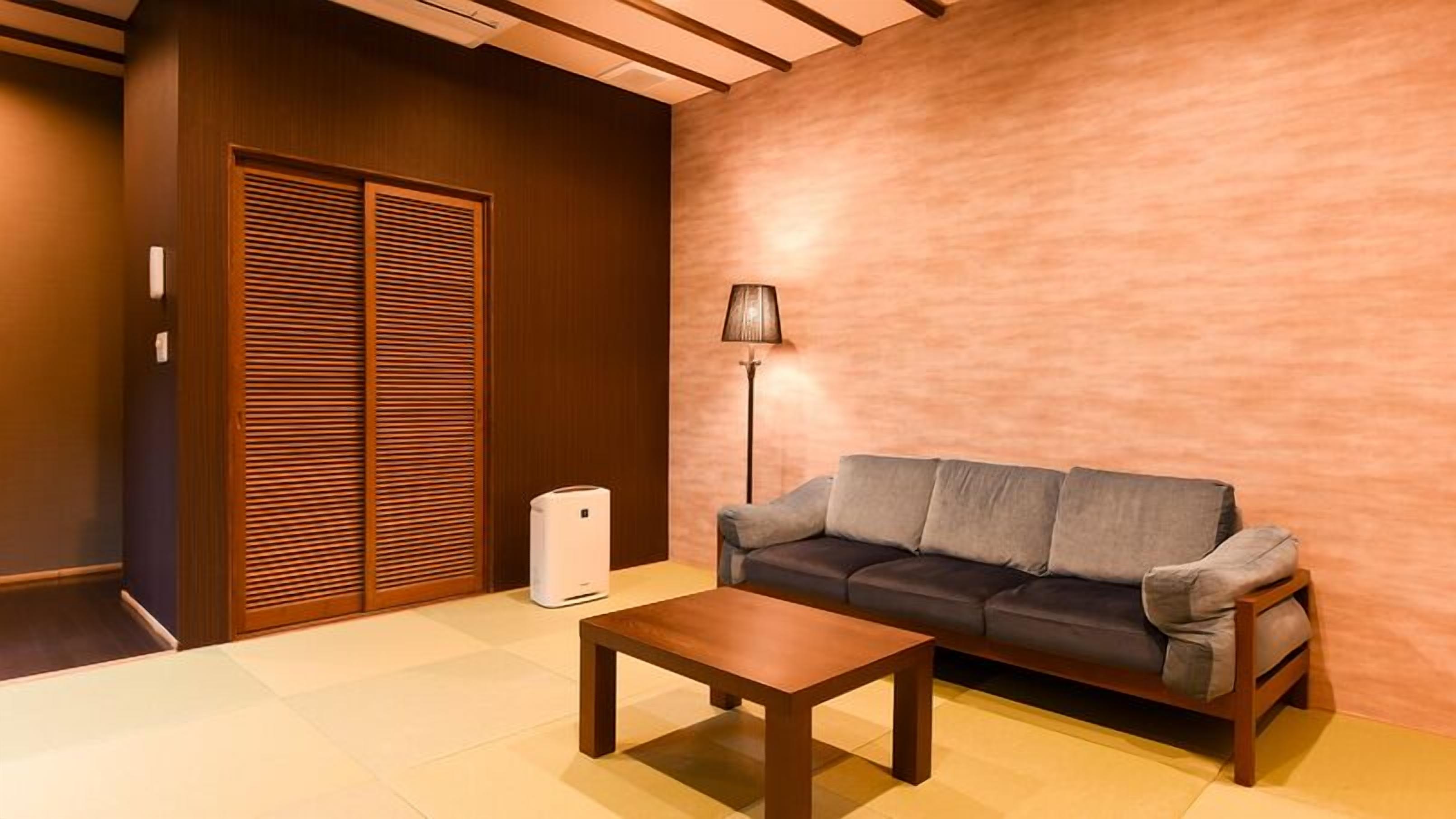 Een moderne woonkamer met een bank, een salontafel, een lamp en een inbouwkast.