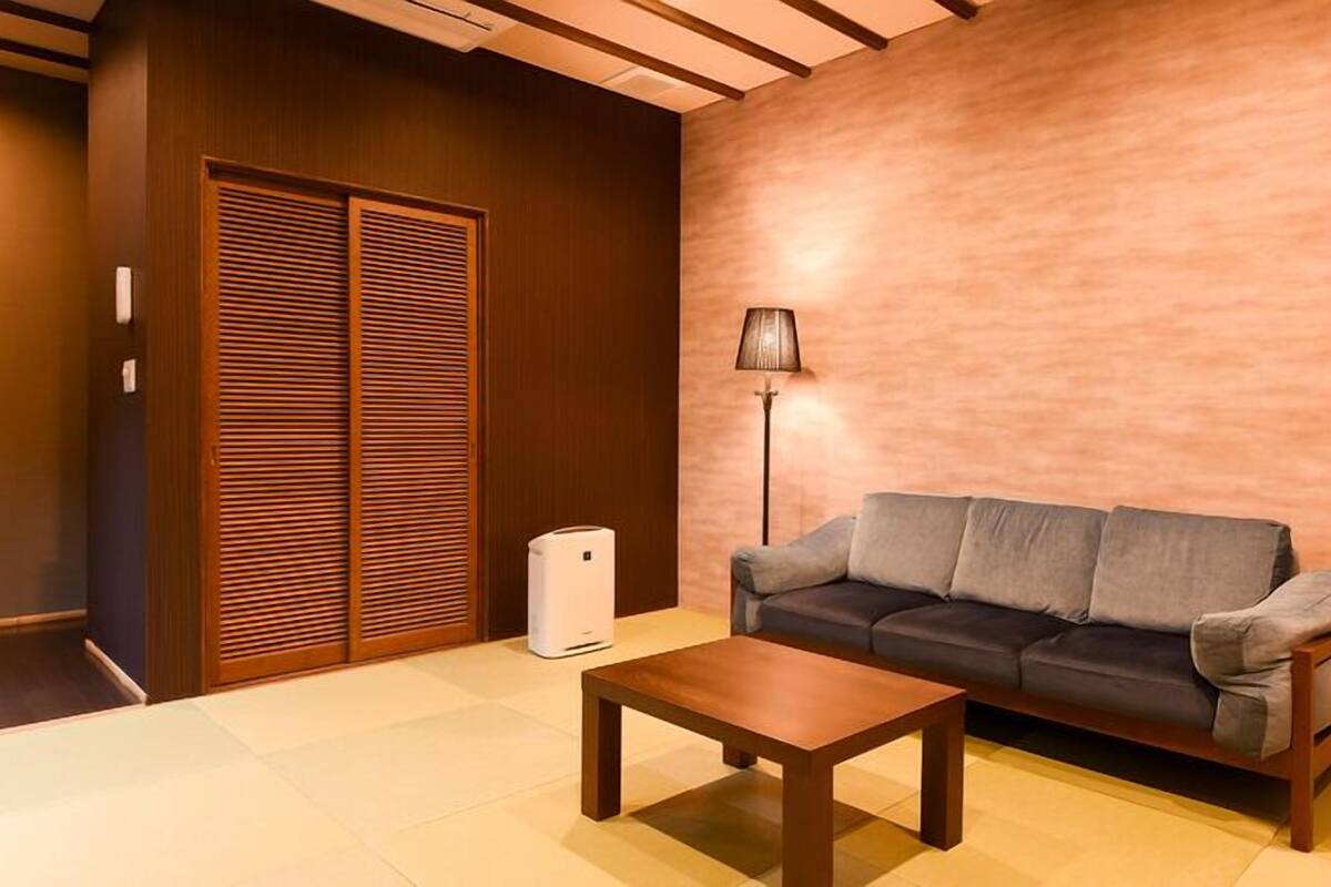 Una sala de estar moderna con sofá, mesa de centro, lámpara y armario.
